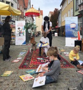 Vorlesefrisör Danny Beuerbach bei einer Straßenaktion mit Kindern